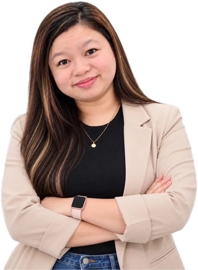 Lucia Anilao smiling with arms crossed, in a beige blazer