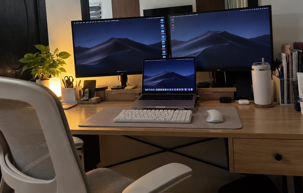 Lucia's desk with two LG monitors and a MacBook Pro on a stand